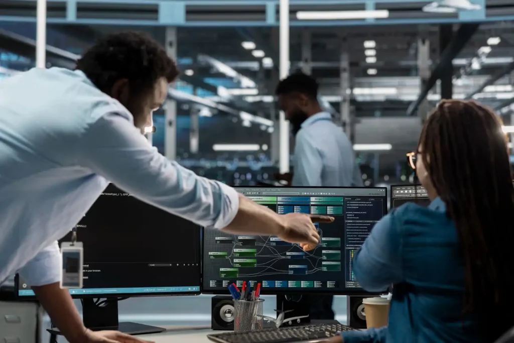 Equipe de profissionais analisando dados e diagramas de arquitetura de dados industrial em um ambiente de tecnologia avançada.