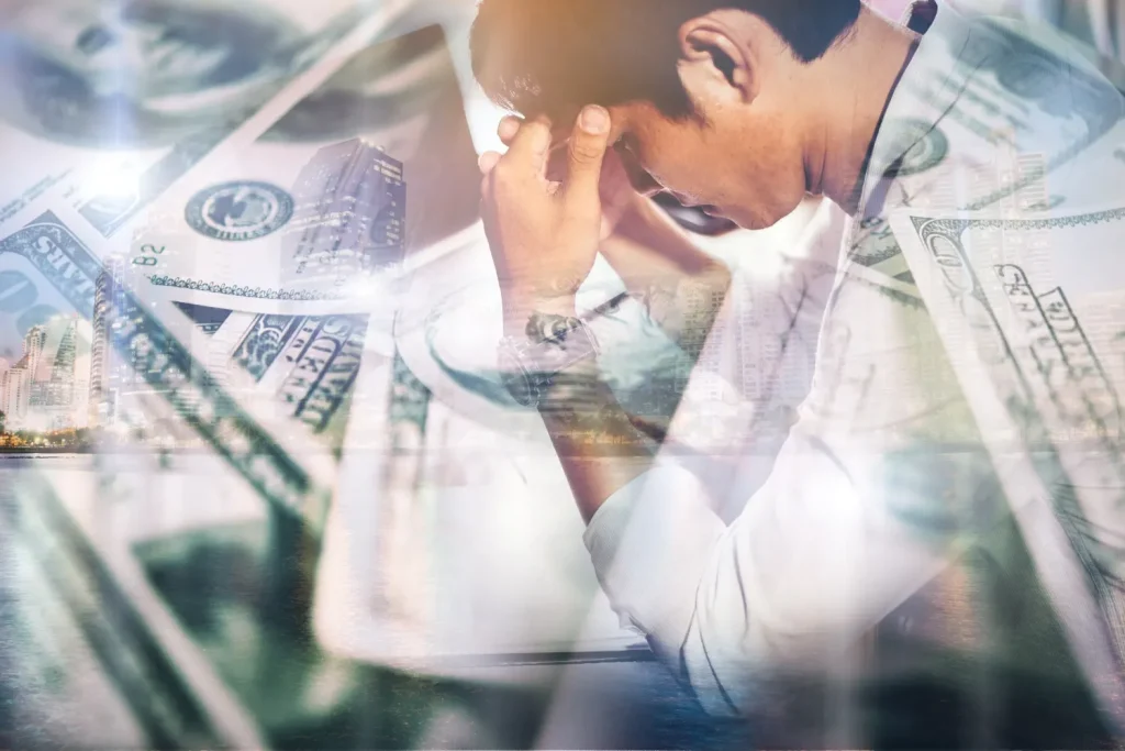 Imagem mostra um empresário preocupado, com o rosto apoiado na mão, enquanto símbolos de dinheiro e gráficos financeiros se sobrepõem, sugerindo Erros Financeiros Que Podem Prejudicar Pequenas Empresas.