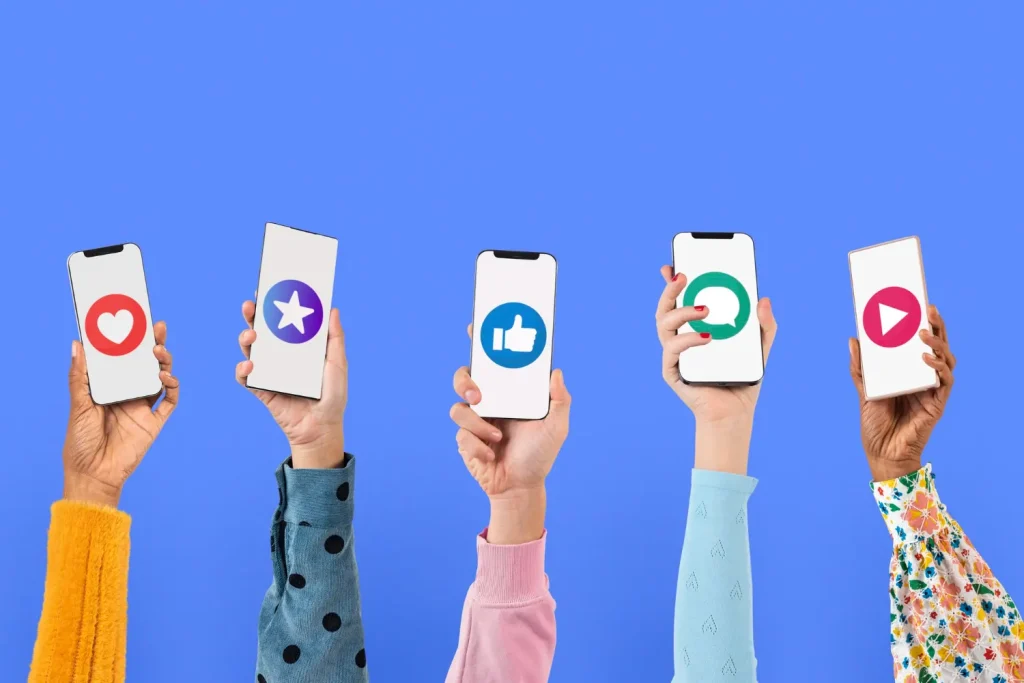 Pessoas segurando celulares com ícones de redes sociais na tela, como coração, estrela, like e logotipo do WhatsApp, em fundo azul. Imagem sobre marketing pessoal e autoridade online