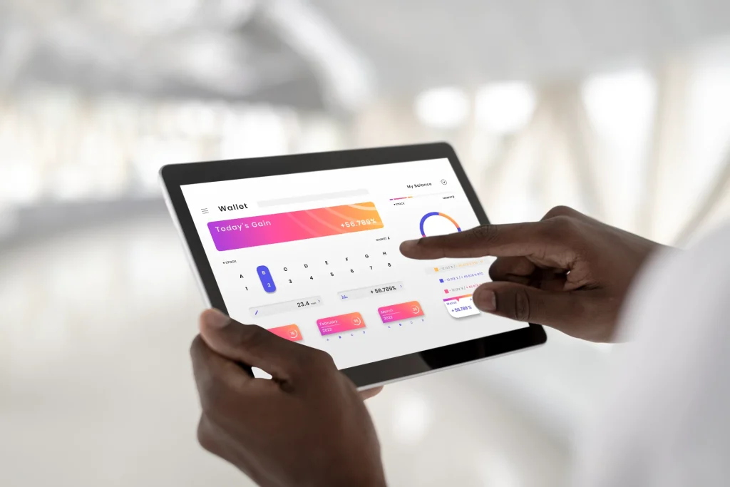Pessoa segurando um tablet com dashboard de métricas de marketing digital, gráficos e indicadores de desempenho para acompanhar resultados e tomar decisões.